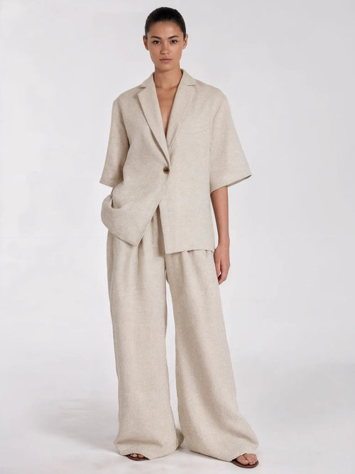 Woman wearing a beige suit on a white background