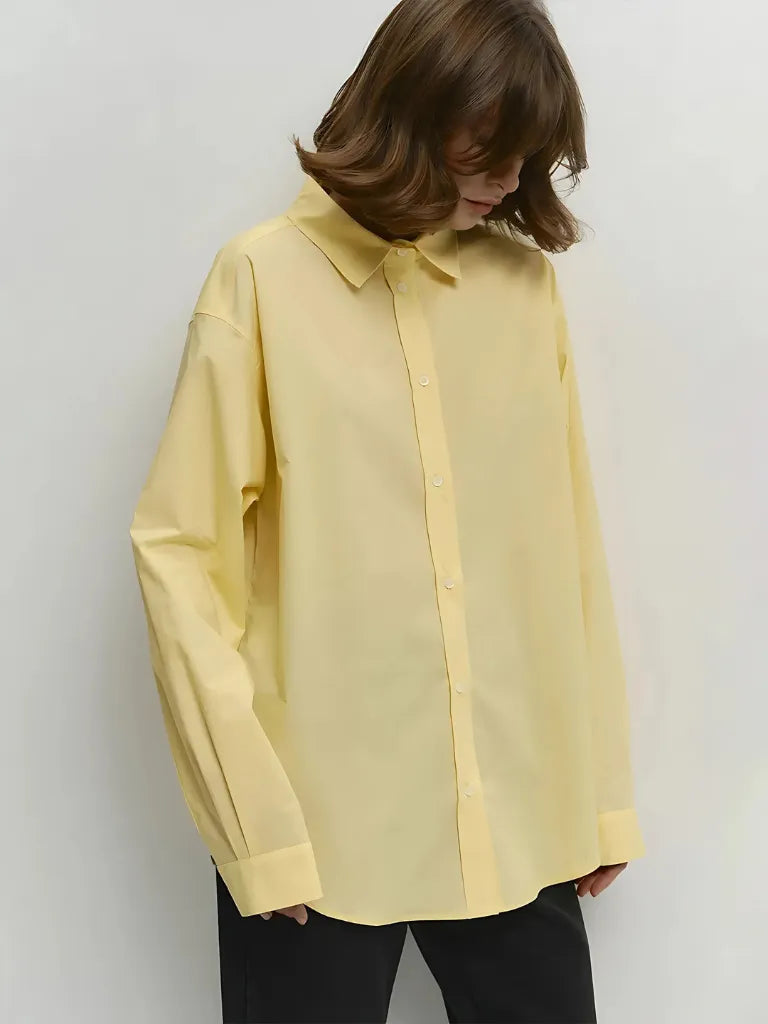 Person wearing a light yellow shirt against a white background