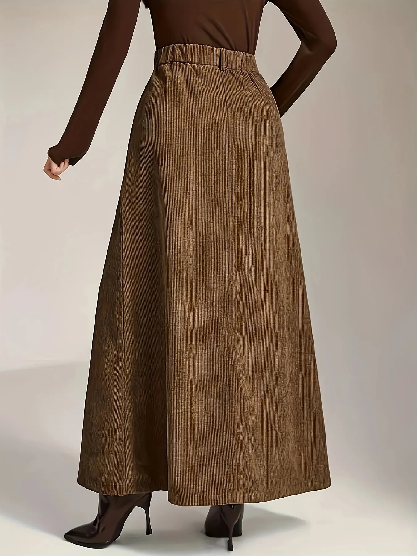 Brown long skirt worn by a person on a plain background