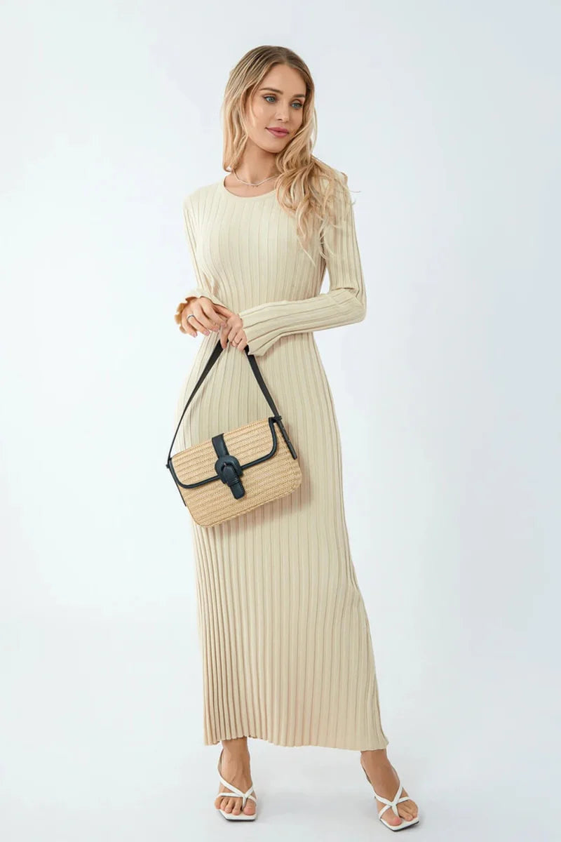 Woman wearing a beige ribbed dress holding a beige handbag on a white background