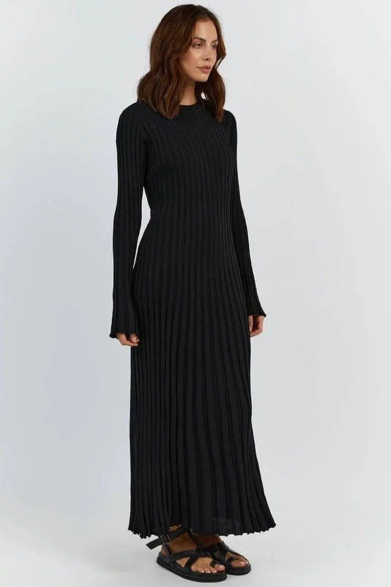 Woman wearing a black pleated dress on a white background