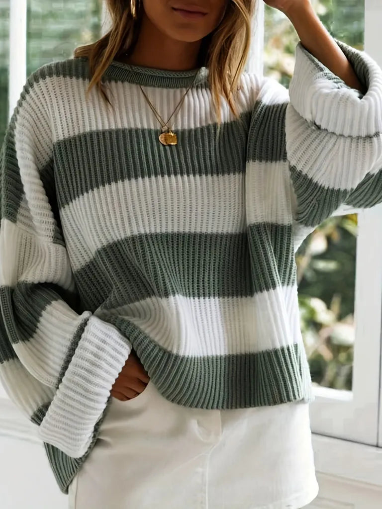 Person wearing a gray and white striped sweater indoors.