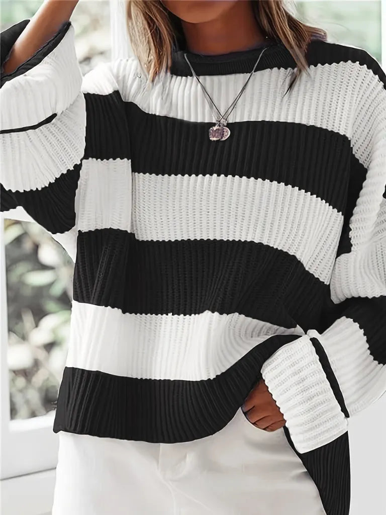 Person wearing a black and white striped sweater with blurred background