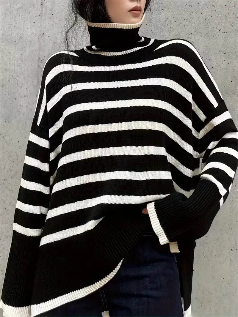Black and white striped sweater worn by a person against a concrete wall.