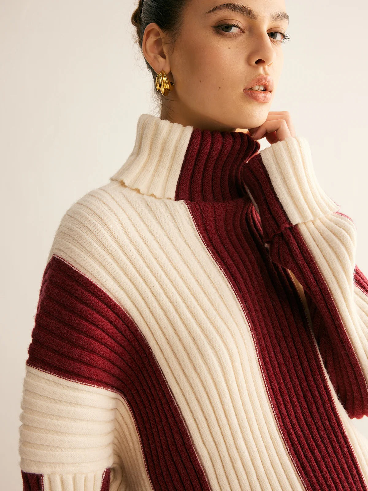Close-up of a person wearing a ribbed sweater with a color block design.
