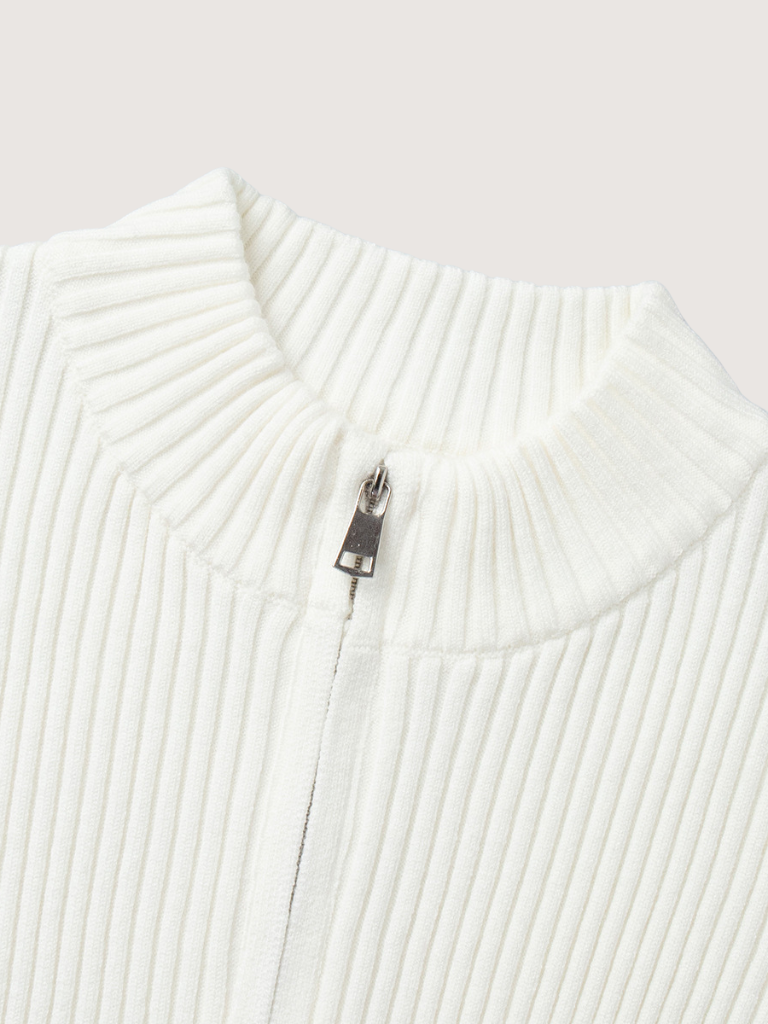 Close-up of a white ribbed sweater with a zipper on a light gray background