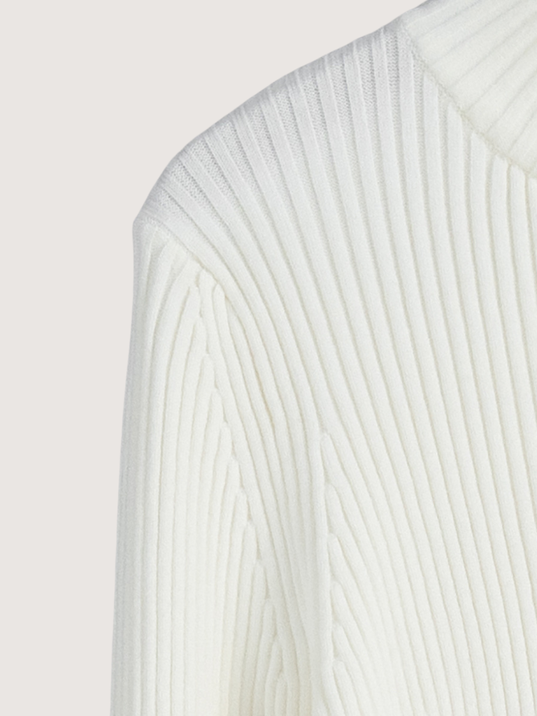Close-up of a white ribbed knit sweater on a light gray background