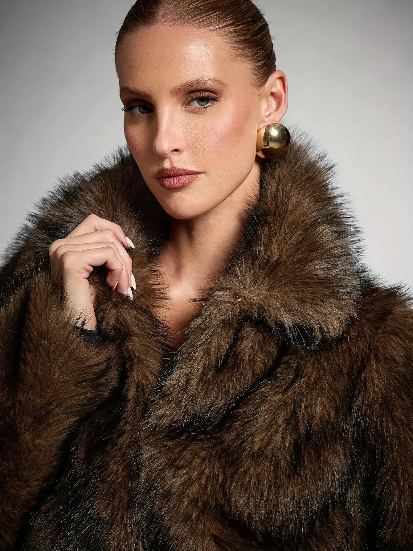 Woman wearing a brown fur coat with a neutral background