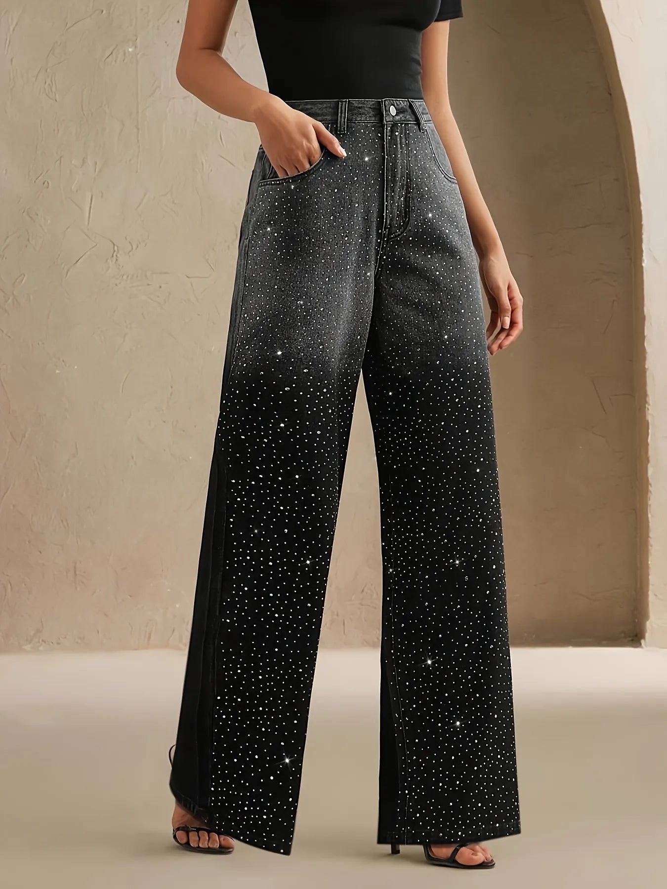Black wide-leg pants with rhinestone embellishments worn by a person against a neutral background