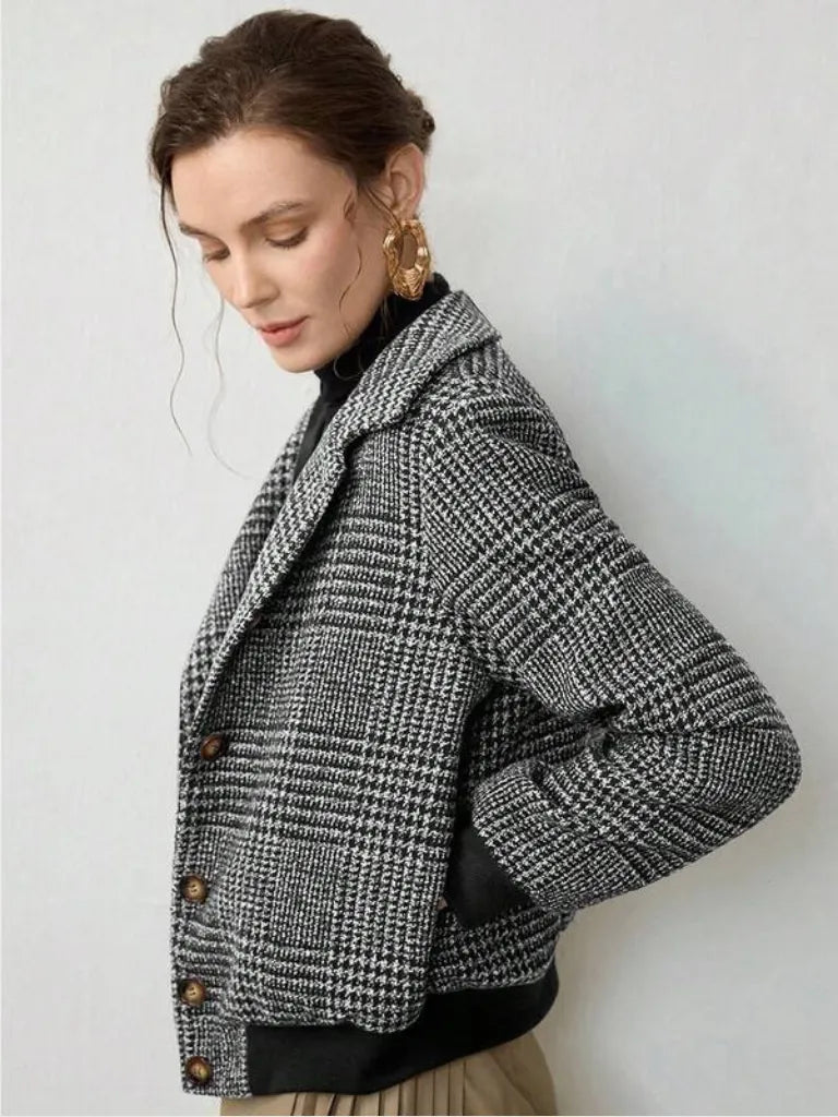 Woman wearing a gray checkered coat against a white background