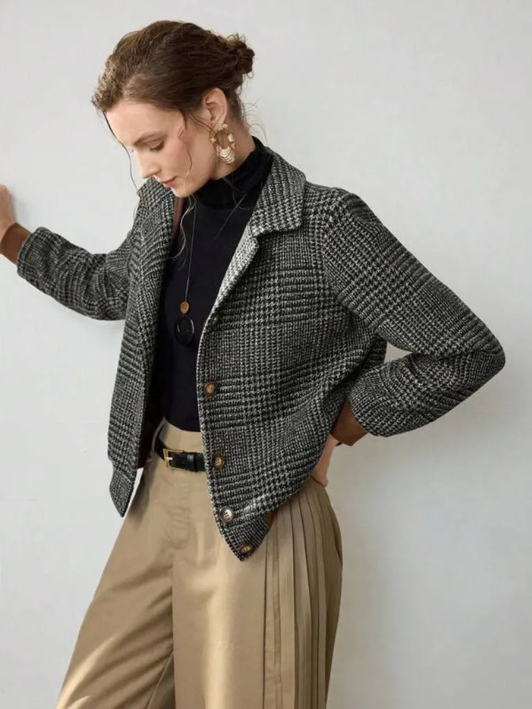 Woman wearing a plaid jacket with a plain background