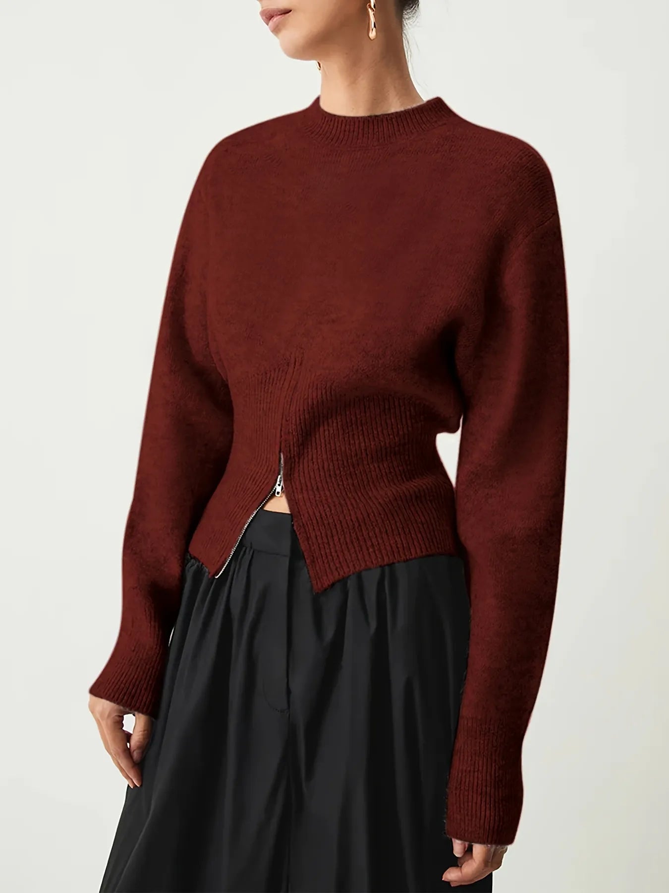 Maroon sweater worn by a person on a white background