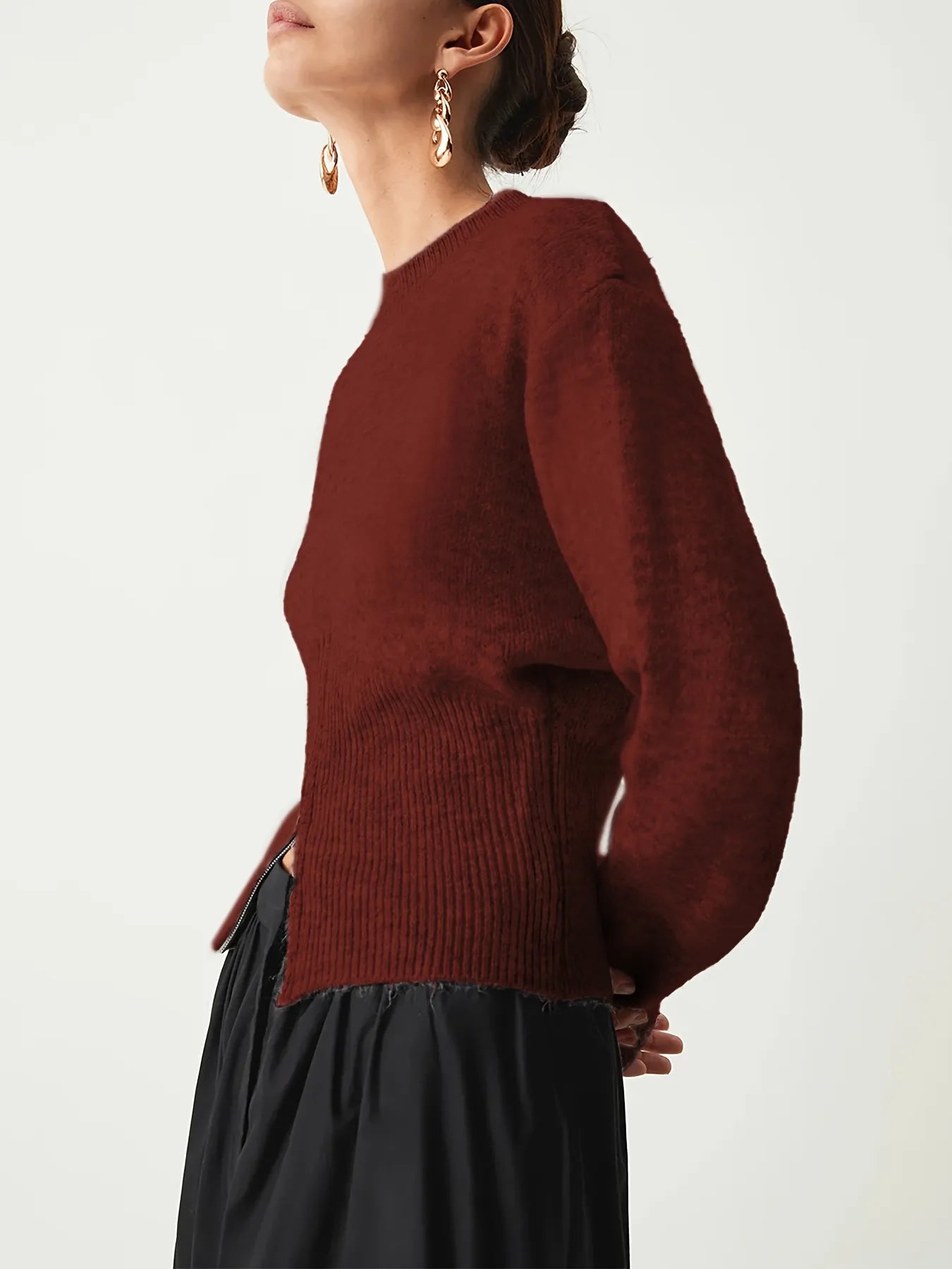 Person wearing a maroon sweater and black skirt on a white background