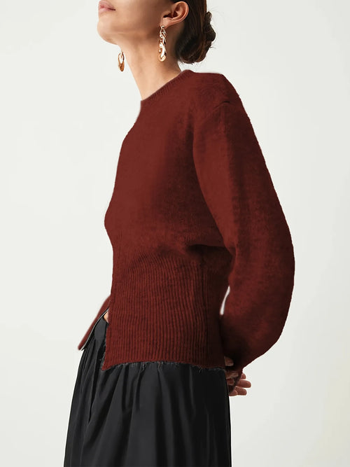 Person wearing a maroon sweater and black skirt on a white background