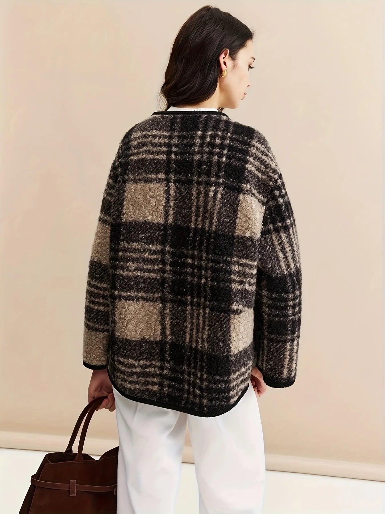 Woman wearing a plaid jacket with a plain background