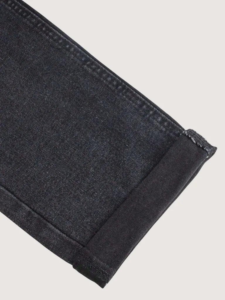 Close-up of dark gray denim fabric on a light gray background