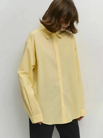 Person wearing a light yellow shirt against a white background