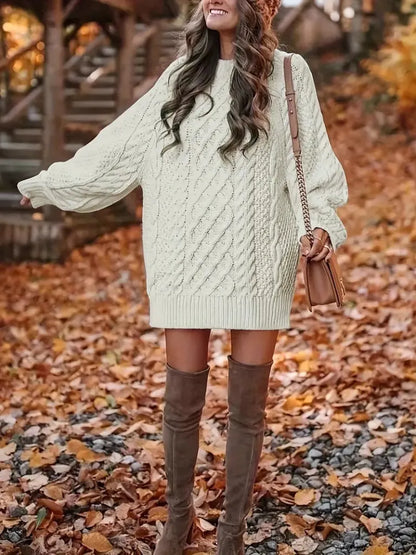 Woman wearing a light green cable knit sweater and brown knee-high boots in an autumn setting.