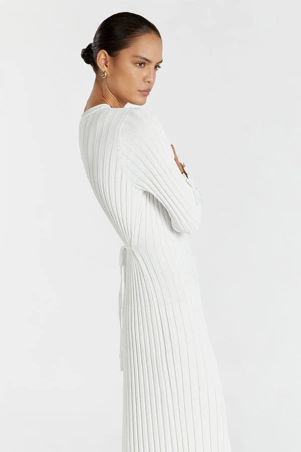Woman wearing a white pleated dress against a white background