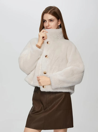 Woman wearing a light beige fluffy jacket with gold buttons on a white background