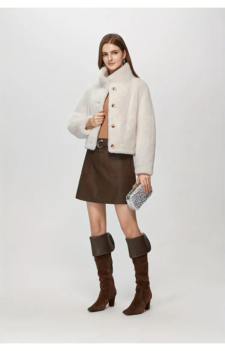 Woman wearing a white coat, brown skirt, and brown boots on a white background