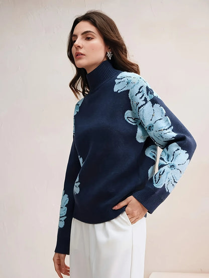 Woman wearing a navy sweater with light blue floral patterns against a plain background