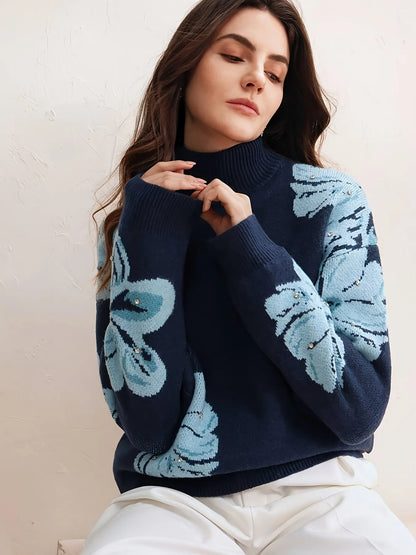 Woman wearing a navy sweater with blue butterfly patterns on a light background