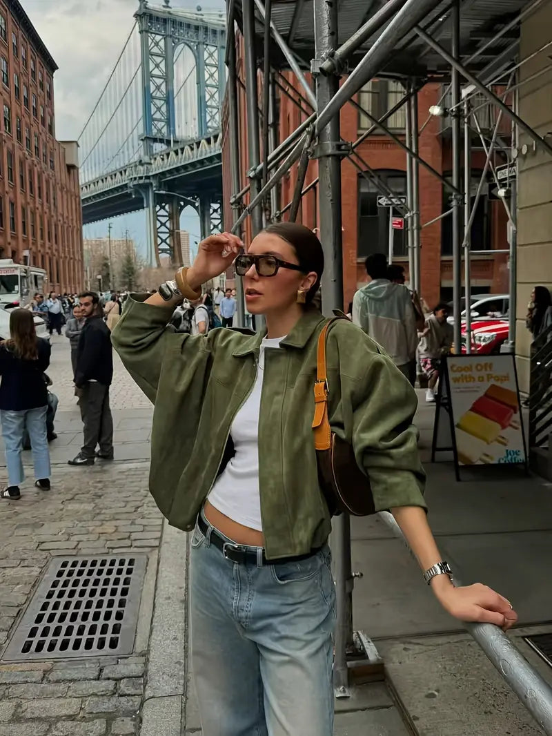 Woman on a city street with a bridge in the background