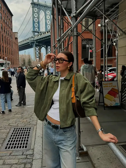 Woman on a city street with a bridge in the background
