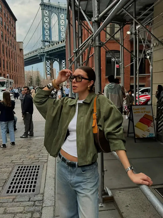 Woman on a city street with a bridge in the background
