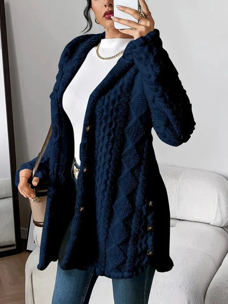 Person wearing a navy blue textured coat indoors.