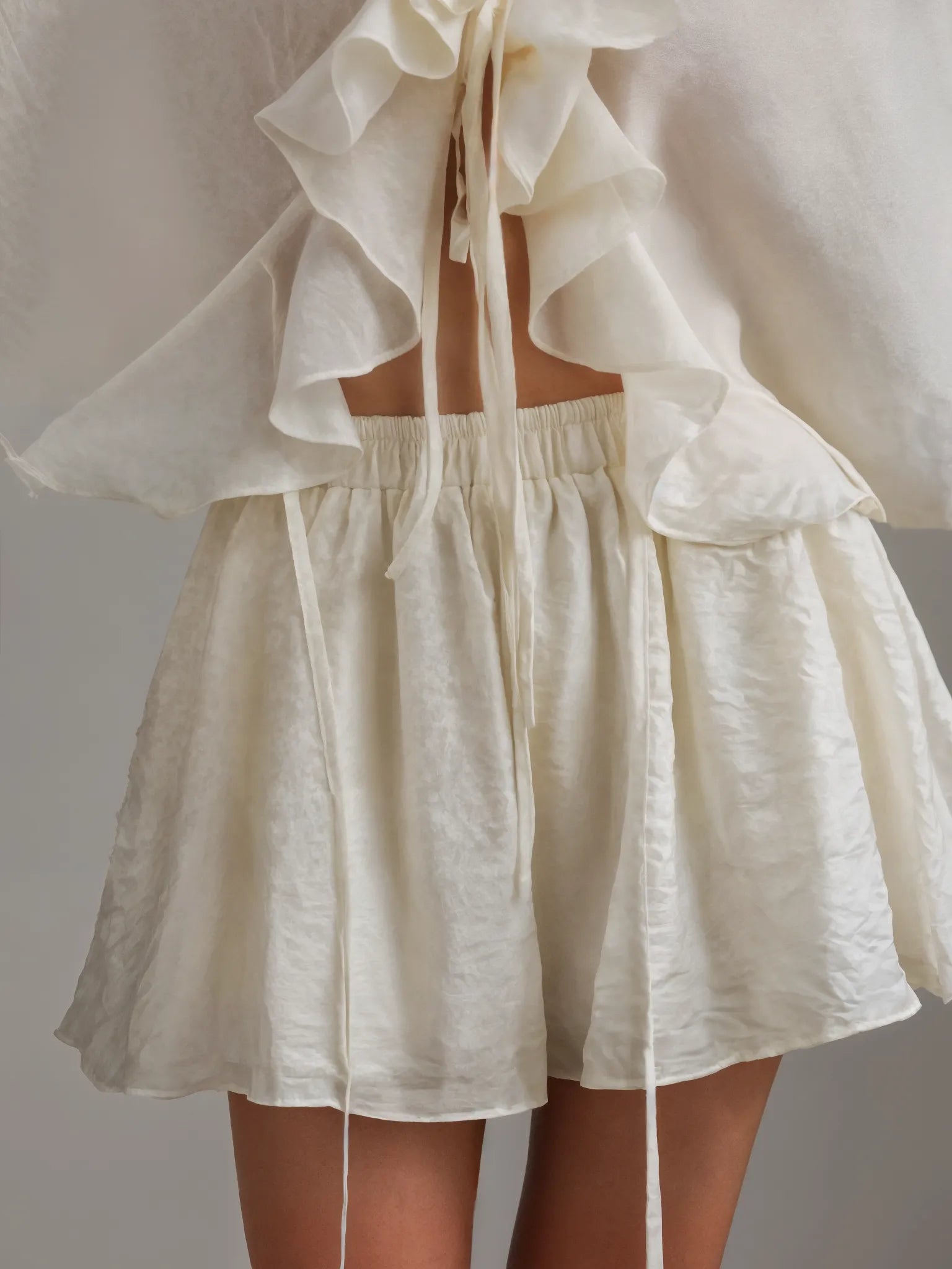 White ruffled top and skirt set on a plain background