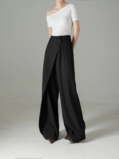 Person wearing a white top and black wide-leg pants on a gray background