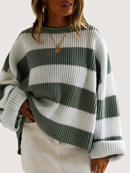 Person wearing a green and white striped sweater on a plain background