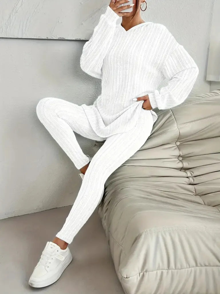 Person wearing a white outfit sitting on a beige bean bag chair.