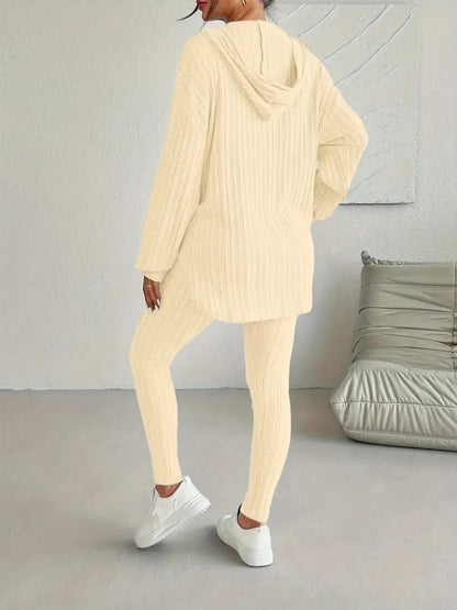 Person wearing a beige knit outfit in a minimalistic room.