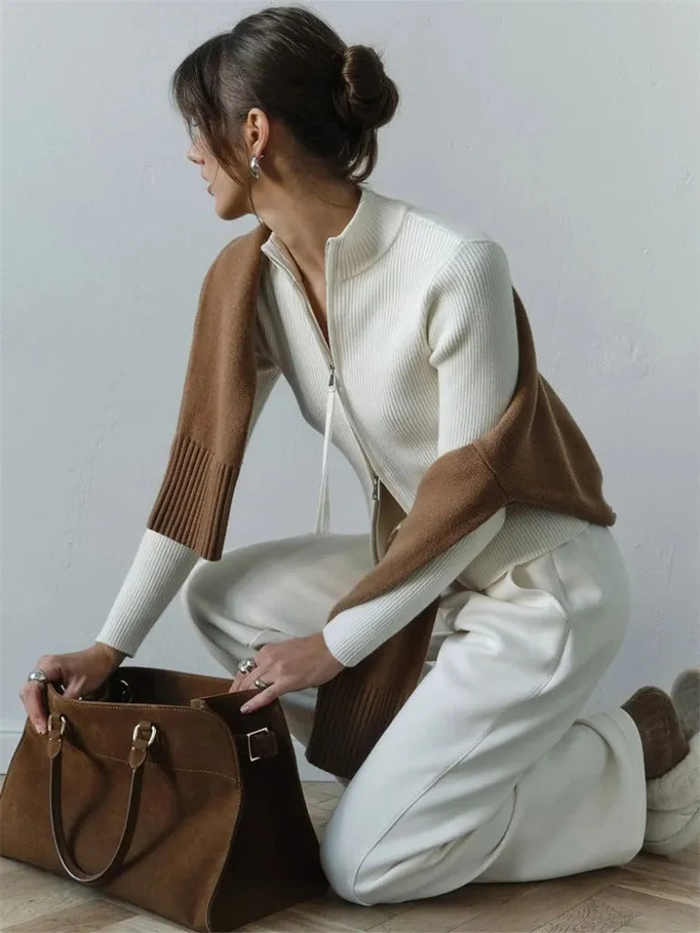 Woman in a white and brown outfit with a large brown bag on a light gray background