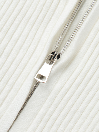 Close-up of a silver zipper on a white fabric background