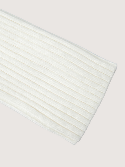 Close-up of a white ribbed knit fabric on a light gray background