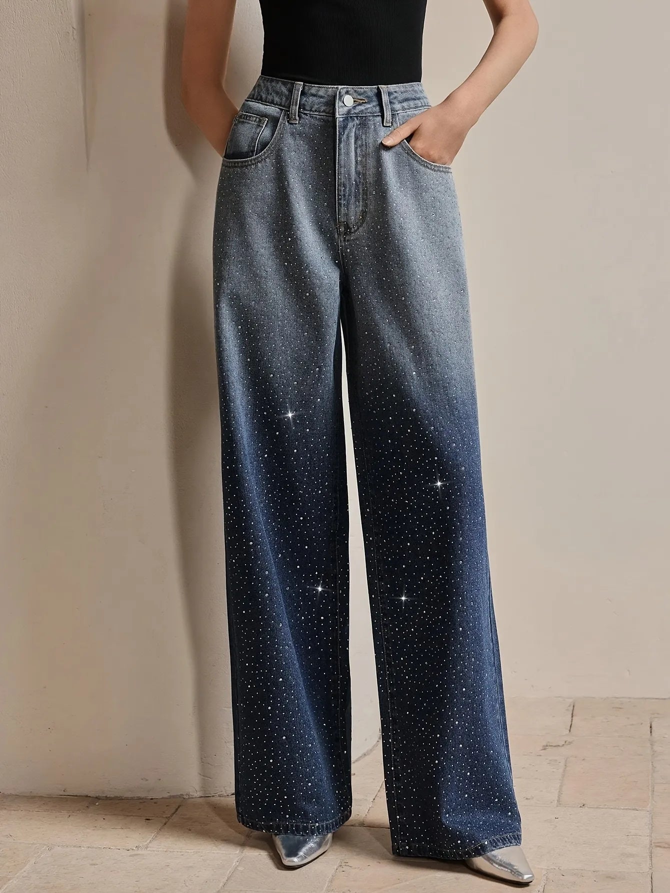 Person wearing wide-leg jeans with a starry pattern against a neutral background