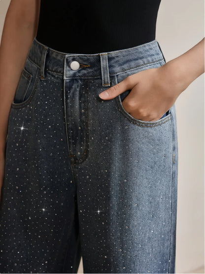 Close-up of a person wearing blue jeans with star patterns on a neutral background