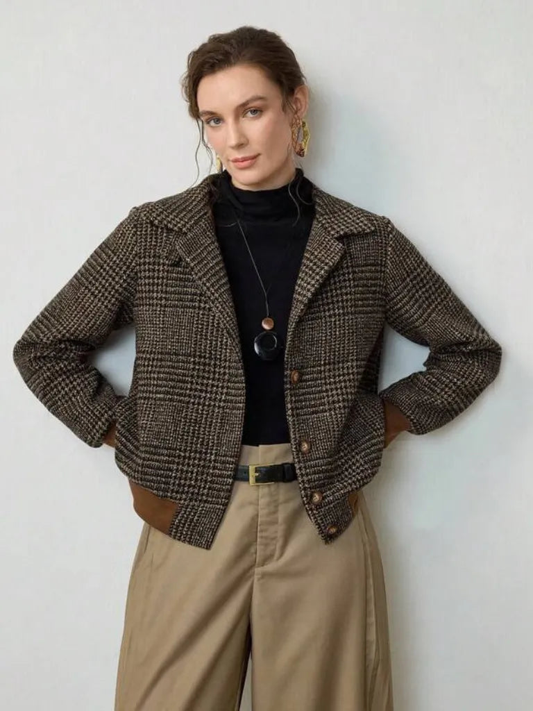Woman wearing a brown plaid jacket with a plain background