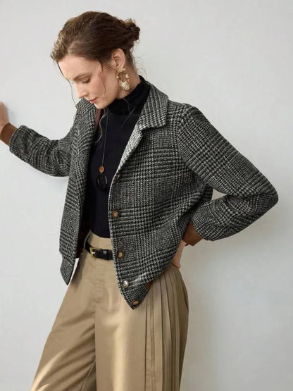 Woman wearing a plaid jacket with a plain background