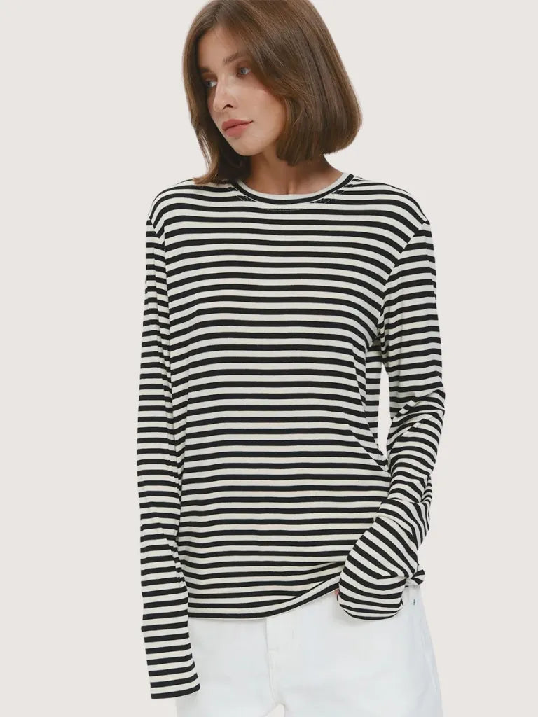 Woman wearing a black and white striped long-sleeve shirt on a light background