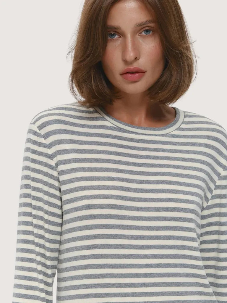 Woman wearing a striped long-sleeve shirt on a plain background