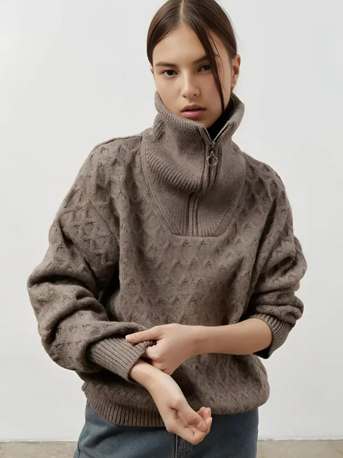 Person wearing a brown patterned sweater against a white background