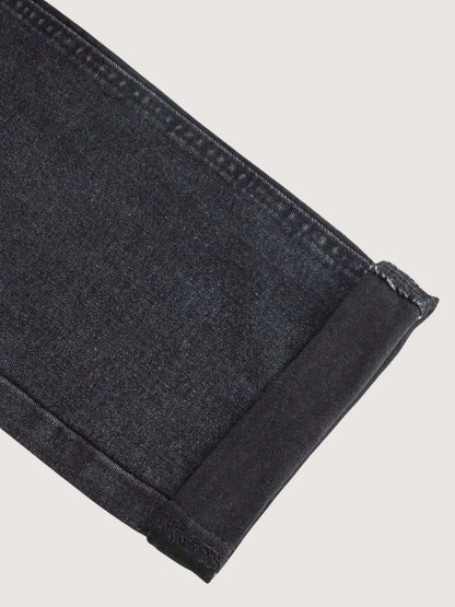 Close-up of dark gray denim fabric on a light gray background