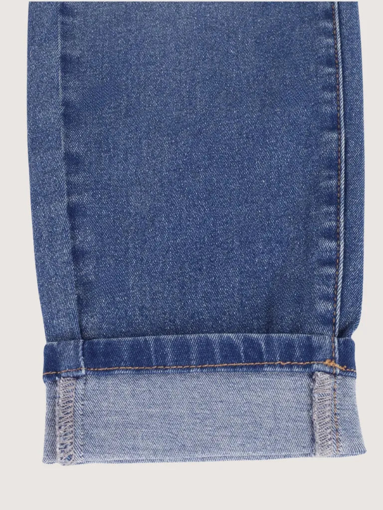 Close-up of blue denim fabric with a white background